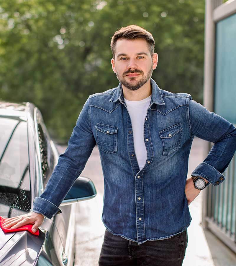 barbat care sta langa masina la spalatorie auto